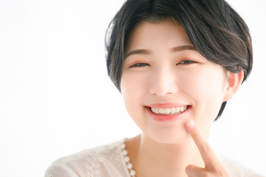 白い歯で笑顔を見せる女性