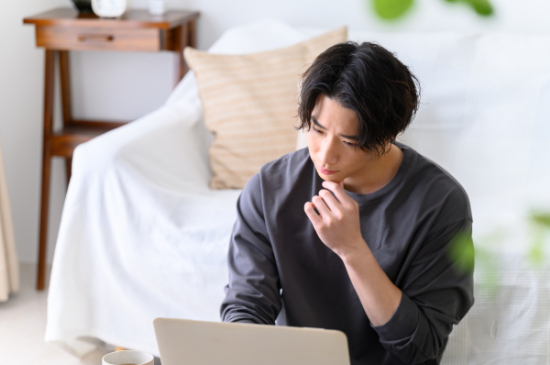 審美歯科の治療が保険適用か調べている男性