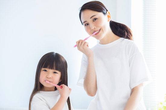虫歯予防のために歯磨きを徹底する親子