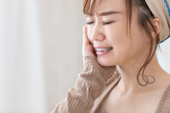 歯周病を放置し歯茎が痛む女性
