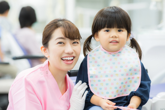 歯科医院を受診した女の子と歯科衛生士の女性