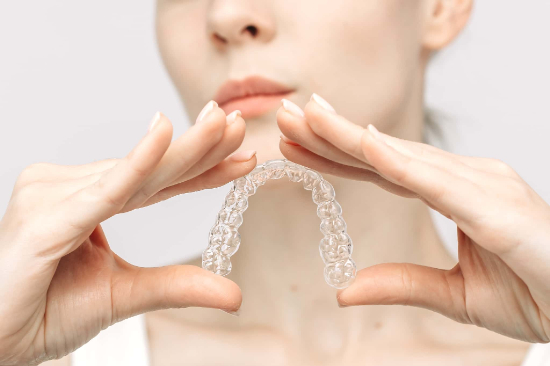すきっ歯の治療に使用するマウスピースを手に持った女性のイメージ