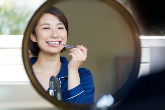歯周病予防のために丁寧に歯磨きをする女性