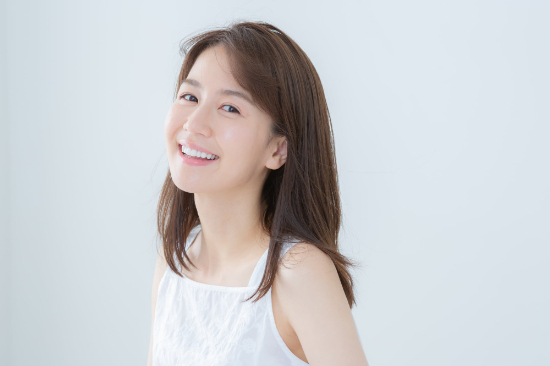 ホームホワイトニングで得た白い歯に満足気な女性