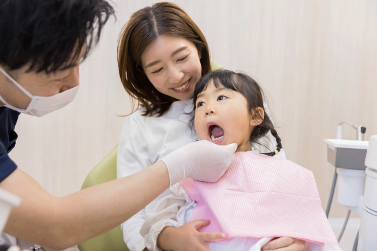 口腔内のチェックを受ける小さい女の子