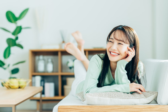 矯正後の後戻りを防いだ女性が笑顔でくつろいでいるイメージ