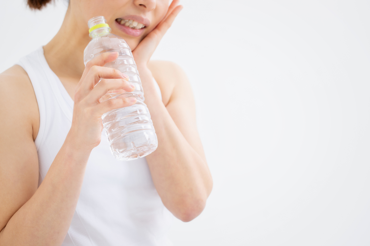 水が歯にしみている女性
