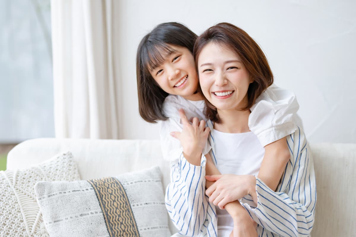 小児矯正をして歯並びが良くなった女の子と笑顔の母親